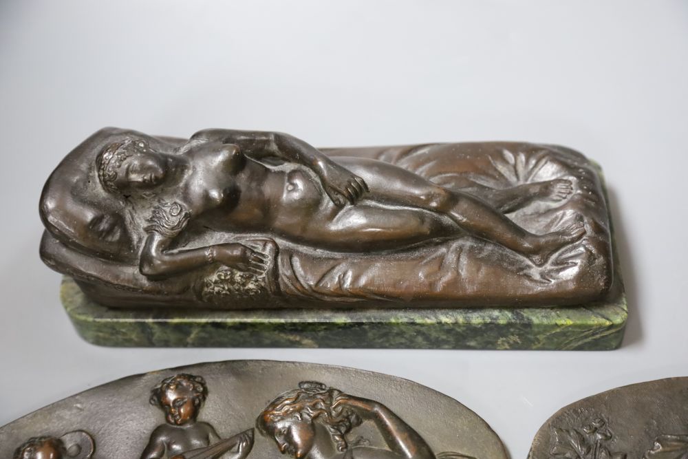 A bronze of a reclining female nude, a pair of plaques and a boy musician